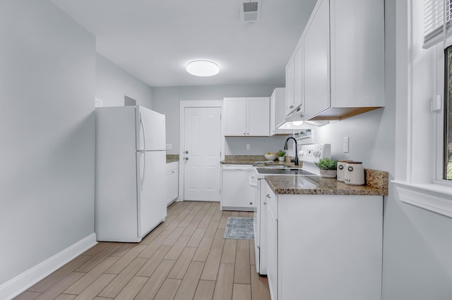 kitchen featuring white appliances, white cabinetry, light wood finished floors, baseboards, and dark stone countertops