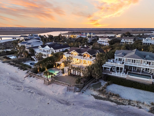 aerial view at dusk featuring a water view