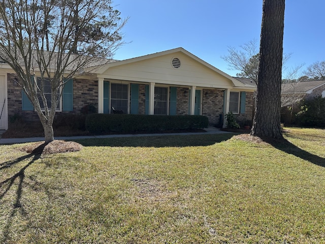 ranch-style home with a front yard and brick siding