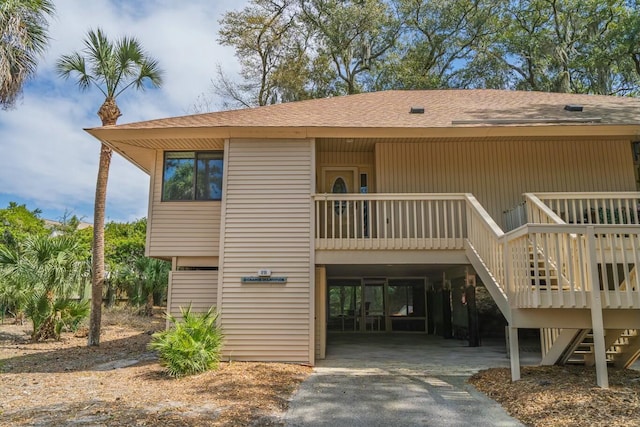 818 Club Cottage Ct, Edisto Beach, SC 29438 - view of front of home featuring stairs, roof with shingles, a carport, a wooden deck, and driveway