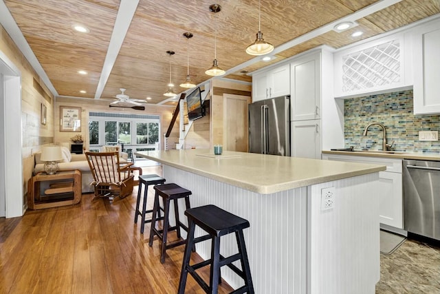 818 Club Cottage Ct, Edisto Beach, SC 29438 - kitchen with stainless steel appliances, wooden ceiling, a ceiling fan, white cabinetry, and decorative backsplash