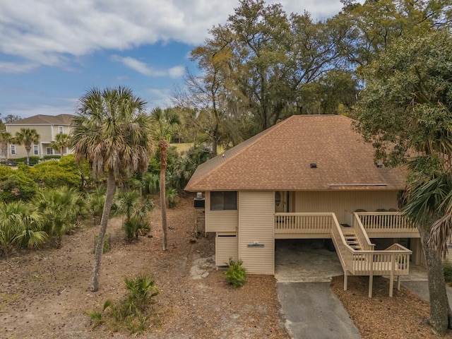 818 Club Cottage Ct, Edisto Beach, SC 29438 - view of front facade featuring concrete driveway, a deck, and a shingled roof