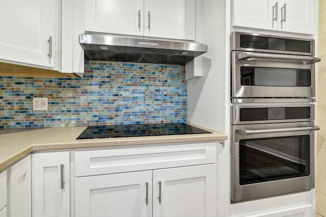 818 Club Cottage Ct, Edisto Beach, SC 29438 - kitchen with ventilation hood, black electric cooktop, decorative backsplash, and white cabinets