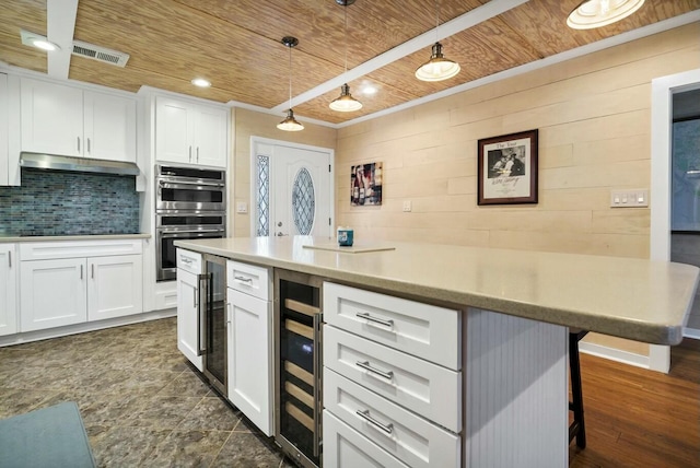 818 Club Cottage Ct, Edisto Beach, SC 29438 - kitchen with wooden ceiling, under cabinet range hood, wine cooler, double oven, and white cabinets