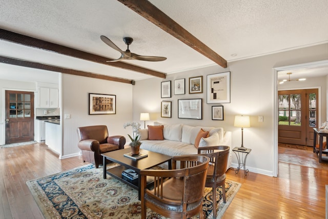 614 Beauregard St, Charleston, SC 29412 - living area featuring a textured ceiling, beamed ceiling, ceiling fan, light wood-style flooring, and baseboards