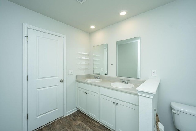 bathroom featuring vanity, wood-type flooring, and toilet