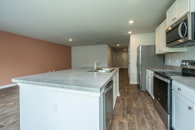 kitchen featuring a kitchen island with sink, sink, decorative backsplash, appliances with stainless steel finishes, and white cabinetry