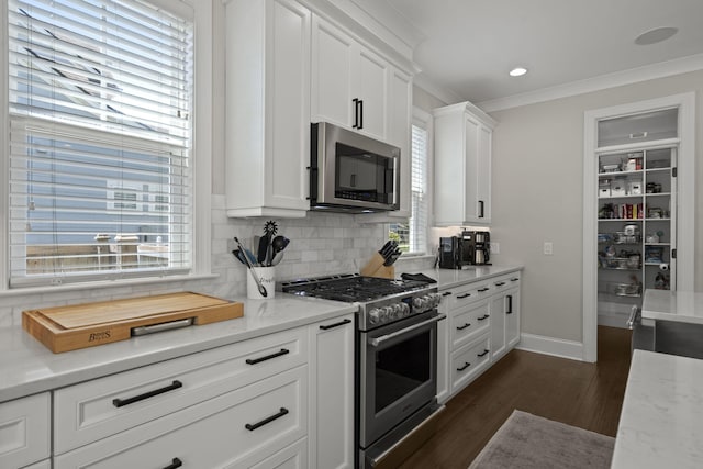 4019 Cascades Thrust, Summerville, SC 29483 - kitchen featuring ornamental molding, dark wood finished floors, white cabinetry, baseboards, and appliances with stainless steel finishes