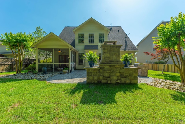 rear view of property featuring a lawn, a patio, ceiling fan, and a fenced backyard