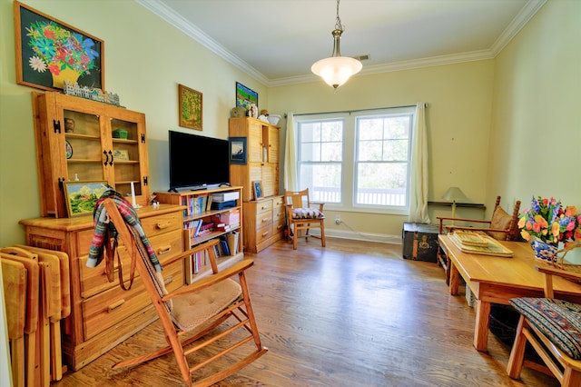 living room with baseboards, visible vents, wood finished floors, and crown molding