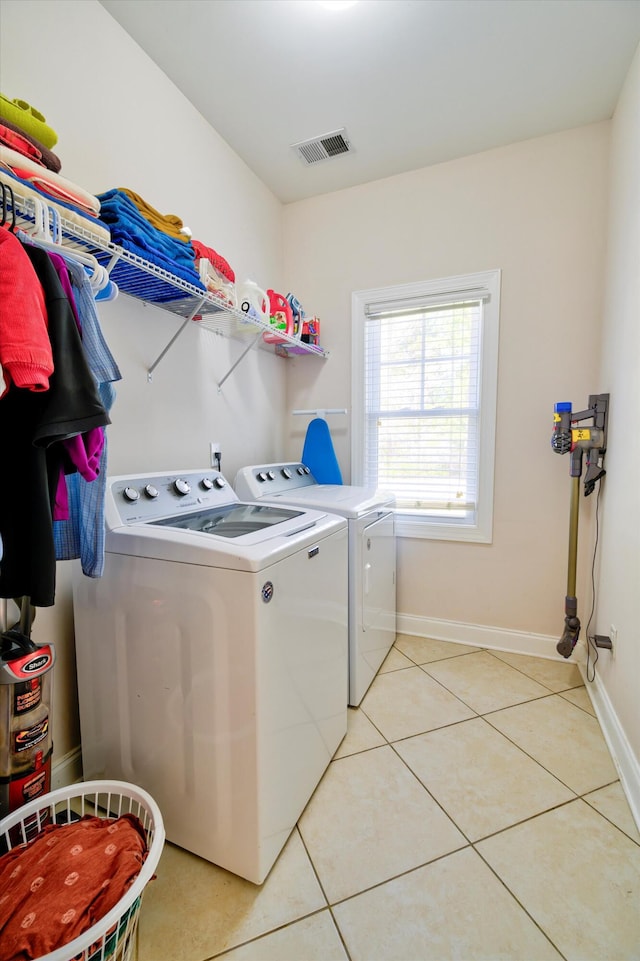 laundry area with visible vents, baseboards, laundry area, washer and dryer, and light tile patterned floors