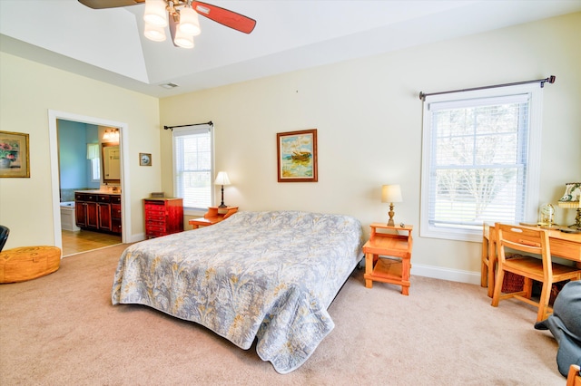 bedroom with lofted ceiling, ensuite bath, baseboards, and light colored carpet