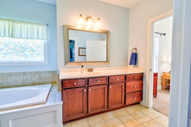bathroom with tile patterned flooring, vanity, and a bath