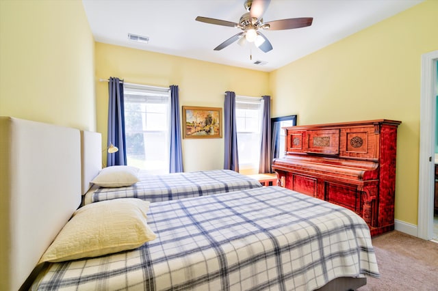 carpeted bedroom featuring baseboards, visible vents, and a ceiling fan