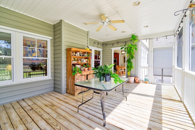 unfurnished sunroom with ceiling fan