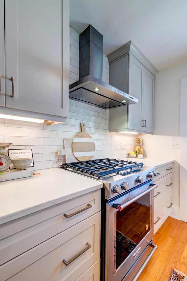 31 Lyttleton Ave, Charleston, SC 29407 - kitchen featuring wall chimney range hood, high end stove, light wood-style flooring, and tasteful backsplash