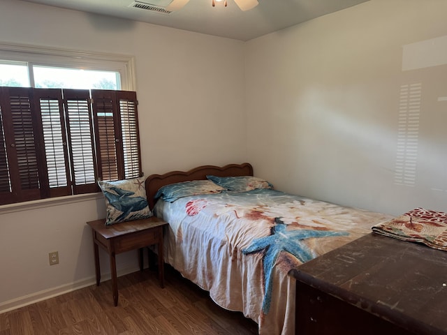 bedroom featuring visible vents, baseboards, wood finished floors, and a ceiling fan