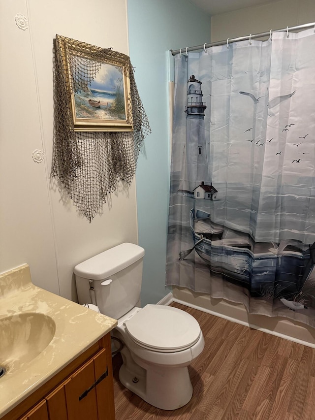 bathroom with shower / tub combo with curtain, toilet, wood finished floors, and vanity