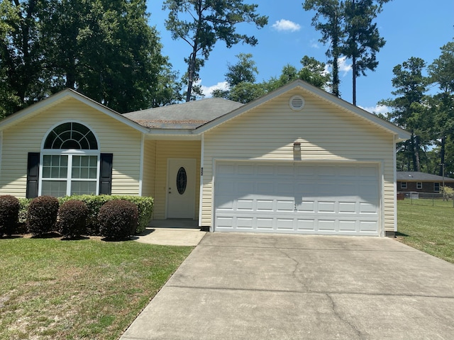 ranch-style house with an attached garage, concrete driveway, a front yard, and roof with shingles