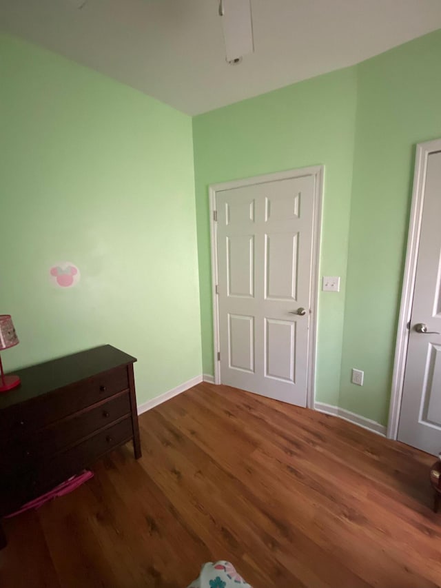 bedroom with wood finished floors and baseboards