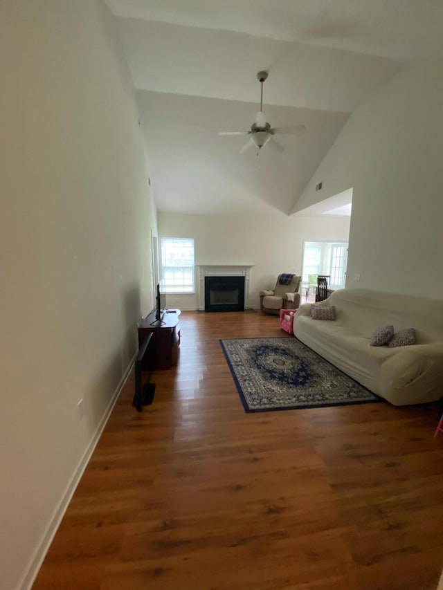 living room with ceiling fan, wood-type flooring, and lofted ceiling