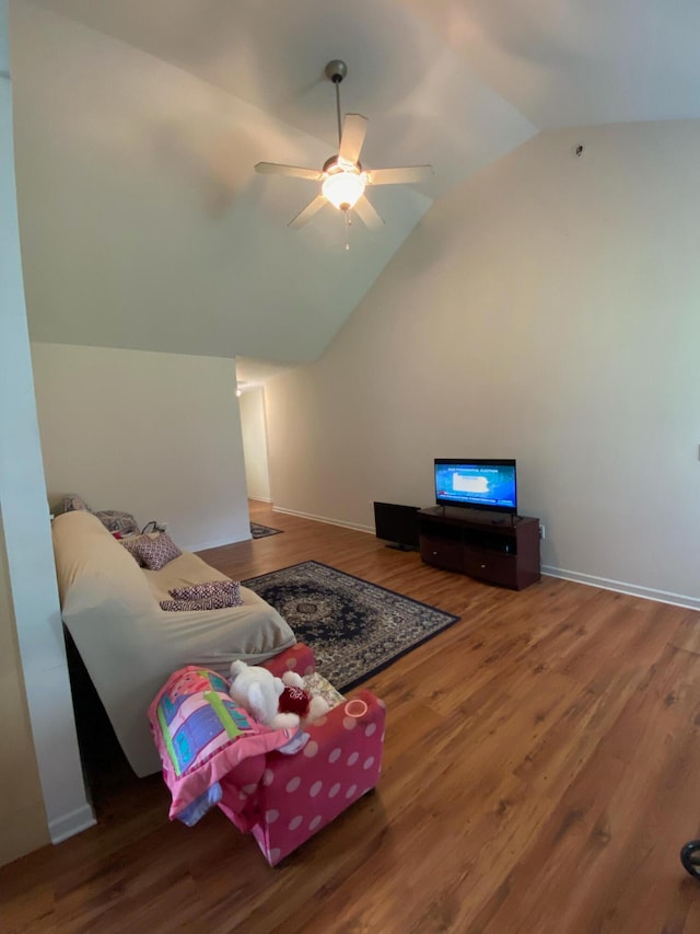 living room with hardwood / wood-style floors, vaulted ceiling, and ceiling fan