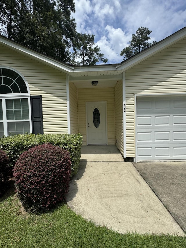 property entrance featuring a garage and driveway