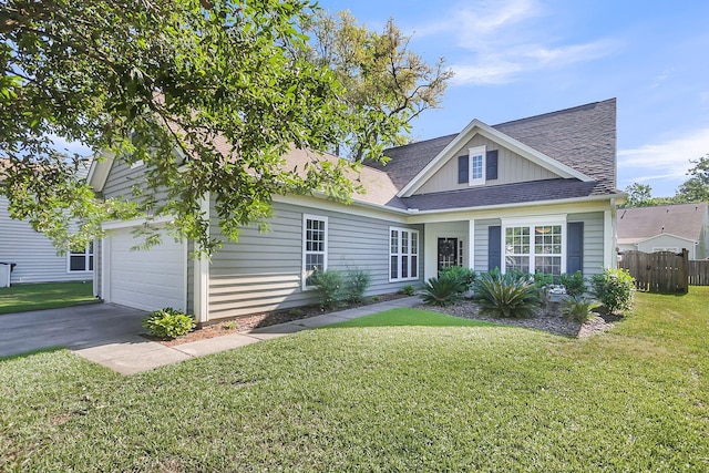 view of front of property with fence, roof with shingles, an attached garage, board and batten siding, and a front yard