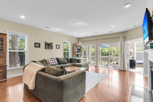 living room with recessed lighting, a fireplace, hardwood / wood-style flooring, and visible vents