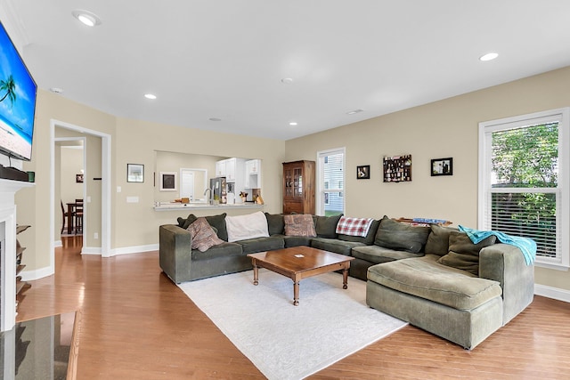 living room featuring recessed lighting, baseboards, and light wood-style flooring