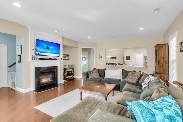 living room with visible vents, a fireplace, wood finished floors, baseboards, and recessed lighting