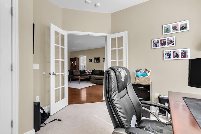 carpeted office space featuring baseboards and french doors