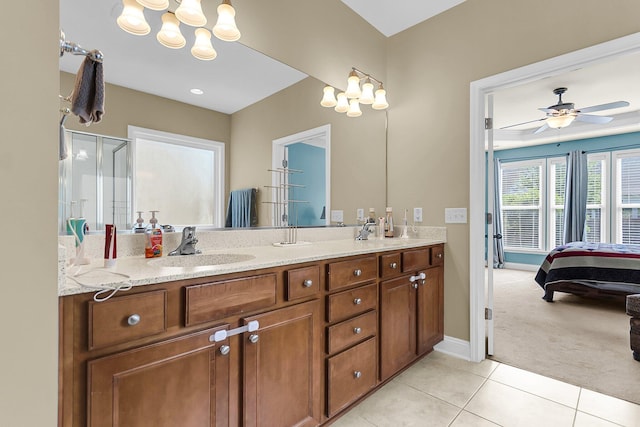 bathroom featuring a sink, tile patterned flooring, double vanity, baseboards, and ensuite bathroom