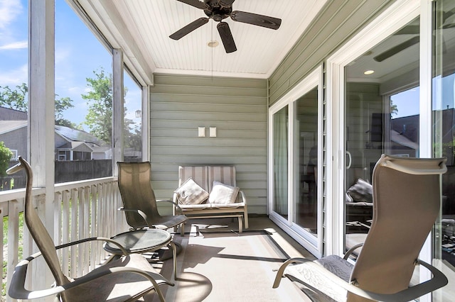 sunroom / solarium featuring a ceiling fan