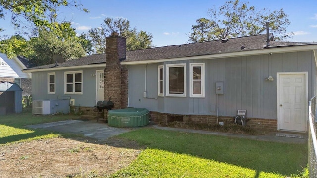 rear view of property featuring a patio area, central AC unit, and a lawn