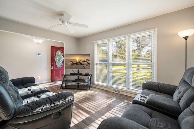 living room with wood-type flooring, ceiling fan, and a wealth of natural light