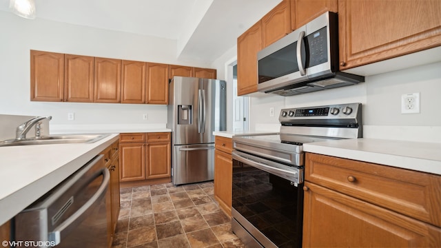 kitchen with dark tile patterned flooring, appliances with stainless steel finishes, and sink