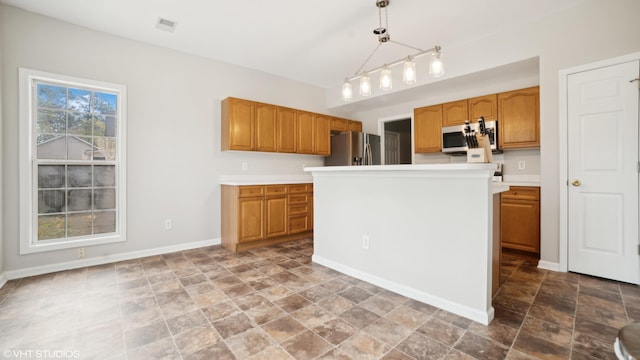 kitchen featuring appliances with stainless steel finishes, tile patterned flooring, pendant lighting, and a healthy amount of sunlight