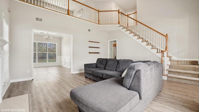 living room featuring an inviting chandelier, a high ceiling, and hardwood / wood-style floors