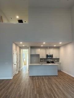 kitchen with a center island, dark hardwood / wood-style flooring, and white cabinetry