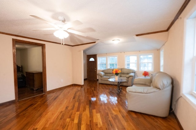 unfurnished living room featuring wood-type flooring, ornamental molding, and ceiling fan