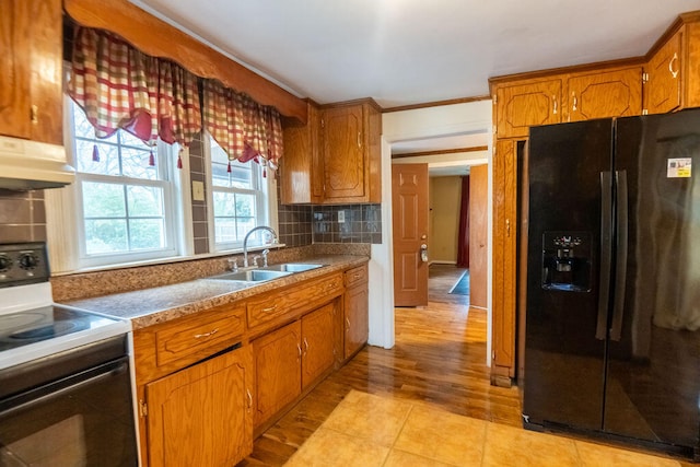 kitchen with sink, tasteful backsplash, crown molding, light tile patterned floors, and black appliances