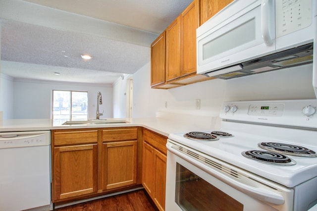 kitchen featuring white appliances, dark wood-type flooring, sink, kitchen peninsula, and a textured ceiling