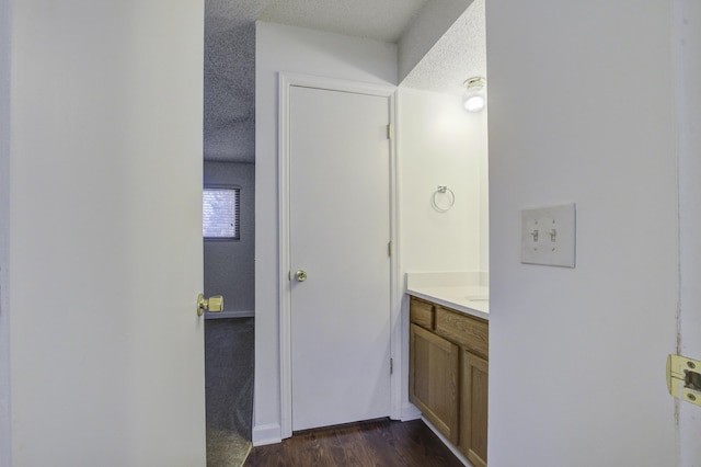 bathroom featuring wood finished floors, vanity, and a textured ceiling