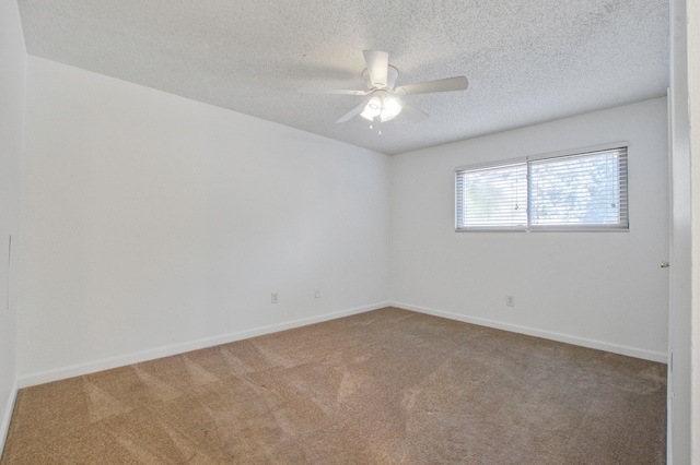 carpeted empty room featuring ceiling fan and a textured ceiling