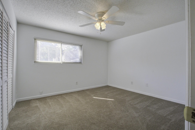unfurnished bedroom featuring baseboards, carpet flooring, a textured ceiling, and a closet