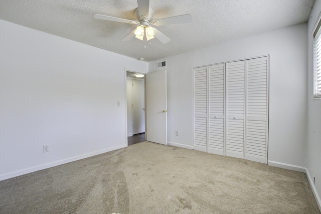 unfurnished bedroom featuring visible vents, carpet floors, a textured ceiling, and a closet