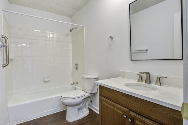 bathroom with wood finished floors, a textured ceiling, vanity, shower / tub combination, and toilet