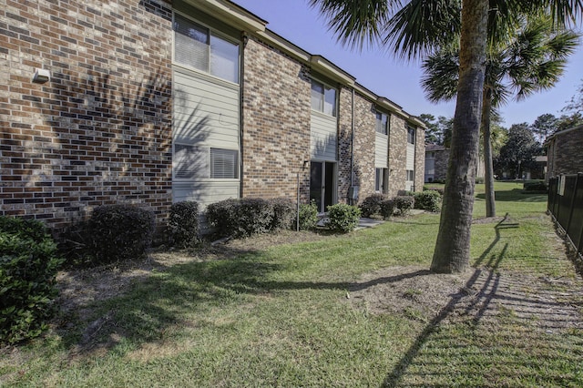 view of side of home with a lawn and brick siding