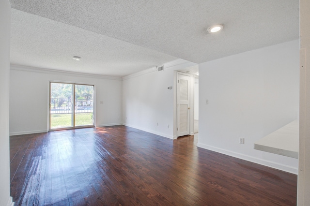 unfurnished room featuring dark wood-type flooring and a textured ceiling